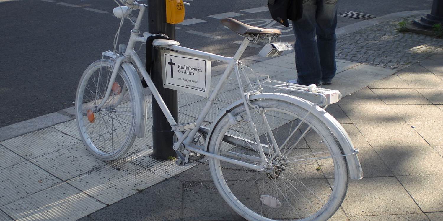 A white-painted bicycle designated as a ghost bike marks the location of where a cyclist was killed—photo: Bukk, Berlin, Germany