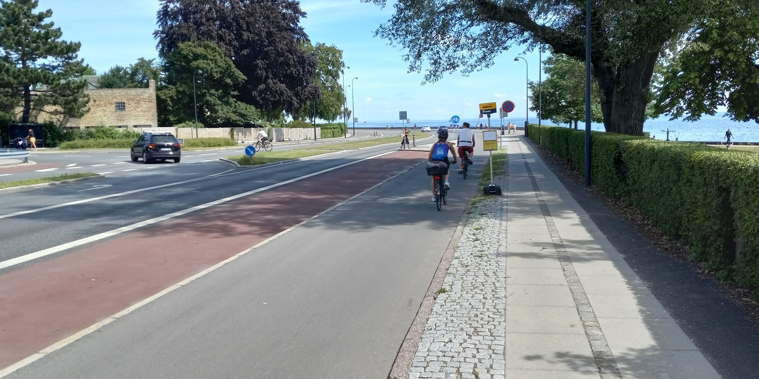 Two cyclists head toward the waterfront on Kystvejen in Charlottenlund, Denmark—Photo: SRR